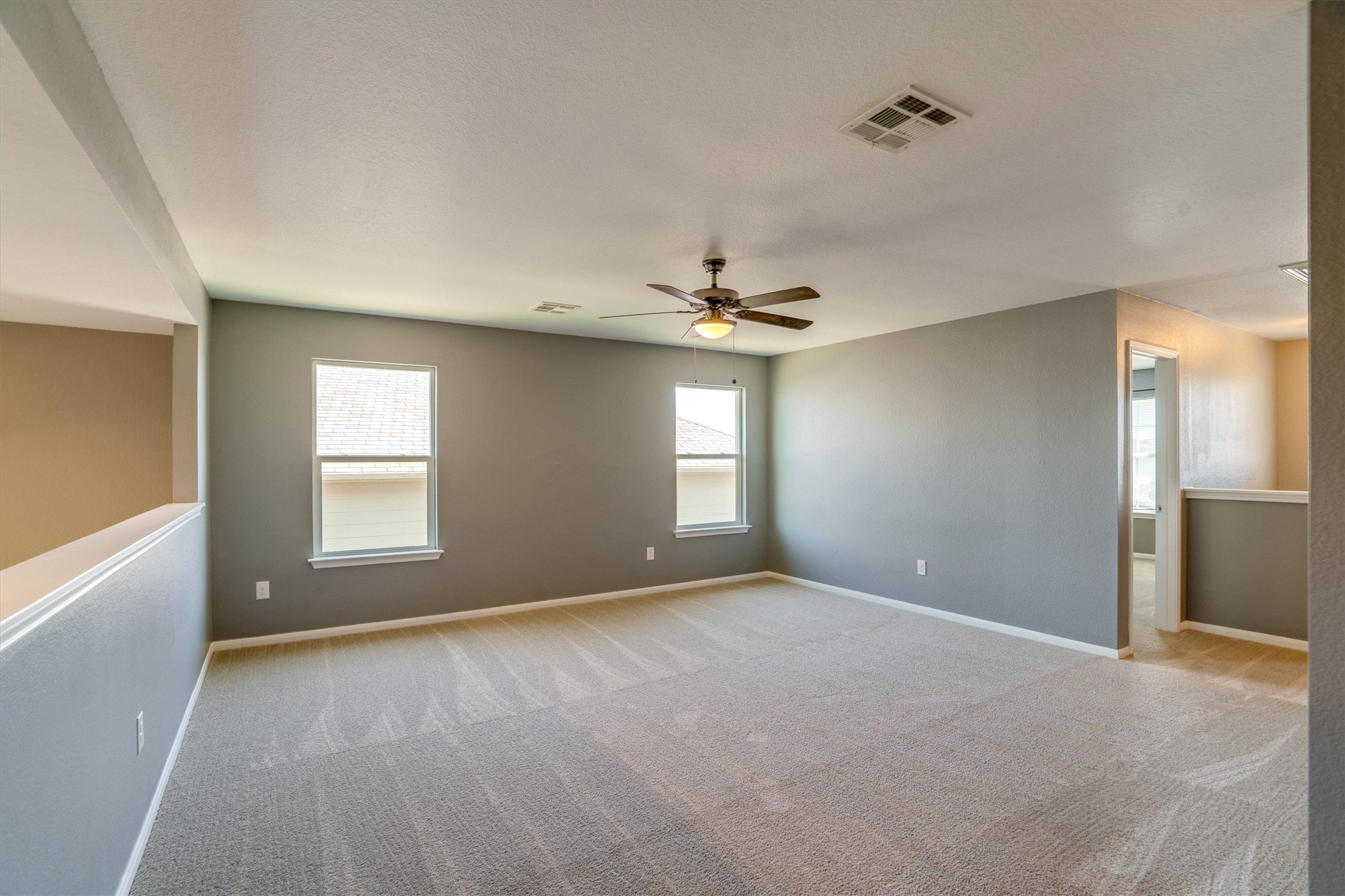 15128 Shell Bark Cove Austin, TX 78724 - Photo 13 of 25 Well-lit and versatile secondary living space with soft carpeting and ceiling fan.