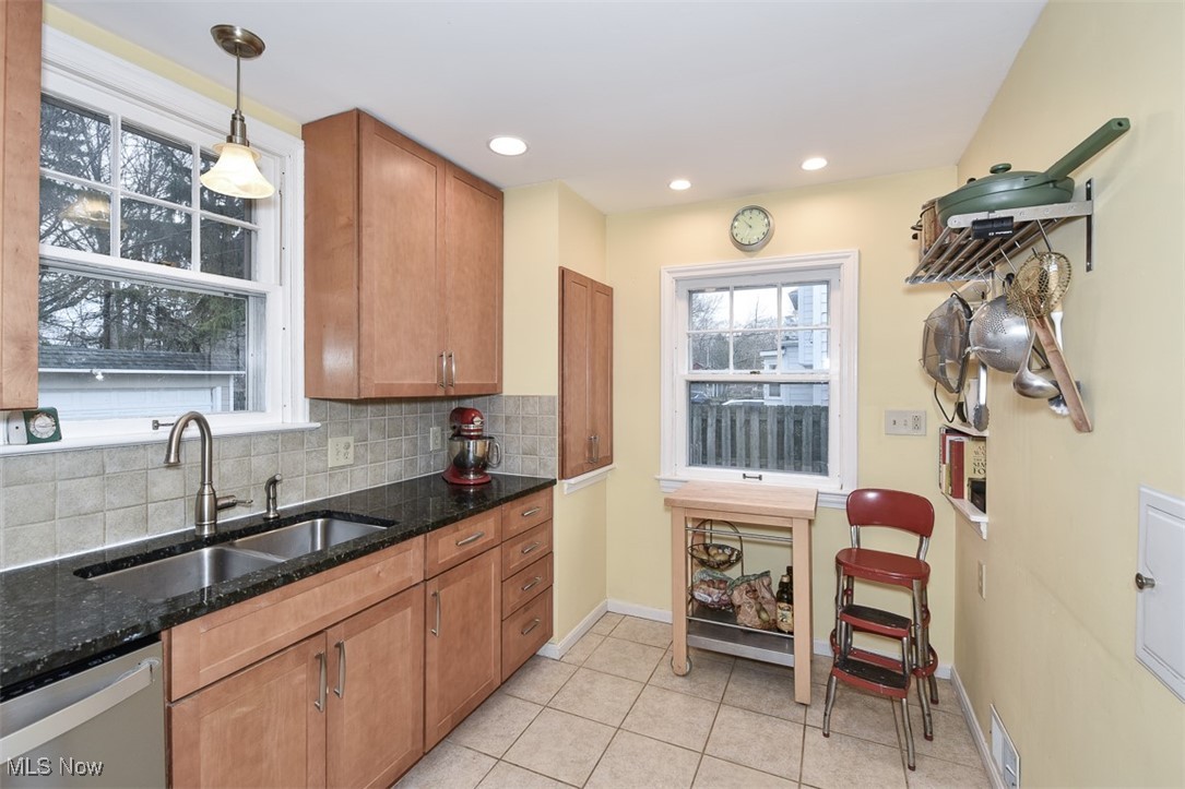 2469 Queenston Road Cleveland, OH 44118 - Photo 11 of 37 Kitchen featuring brown cabinetry, visible vents, a sink, dishwasher, and backsplash