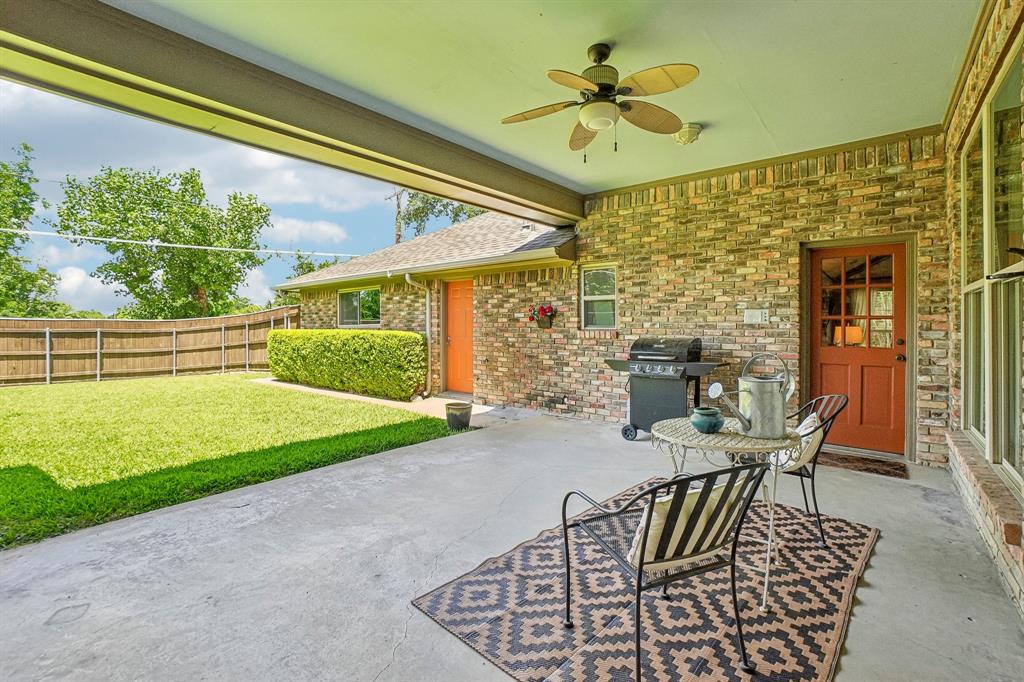 12929 Jasoncrest Trail Dallas, TX 75243 - Photo 32 of 38 Covered patio featuring a ceiling fan, brick exterior, and a rich wood-paneled door