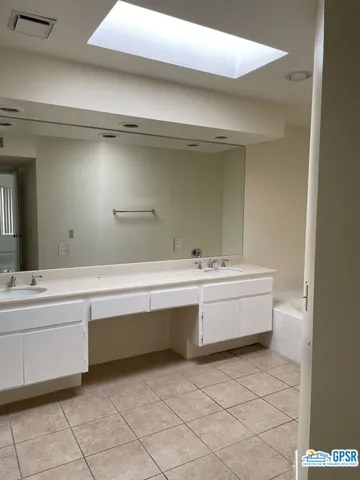 a spacious bathroom with a granite countertop sink and a bathtub