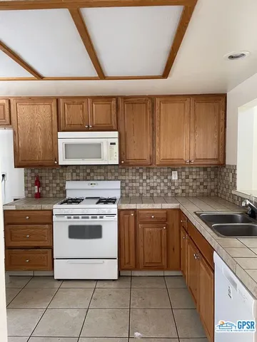 a kitchen with a stove sink and cabinets