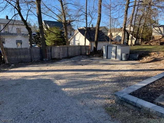 a view of a house with a yard and large tree