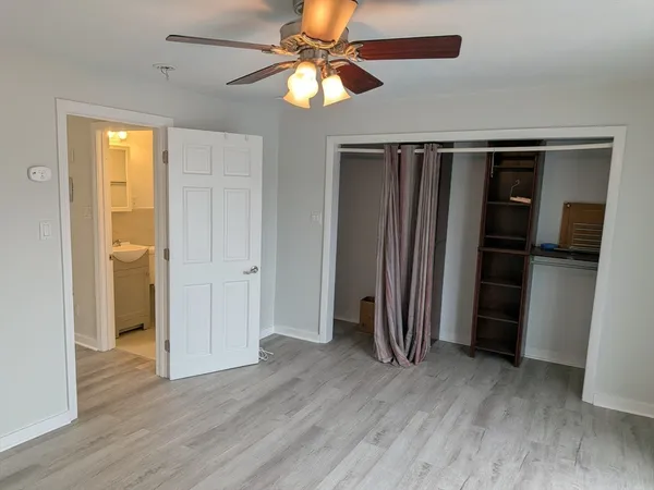 an empty room with wooden floor closet and entryway