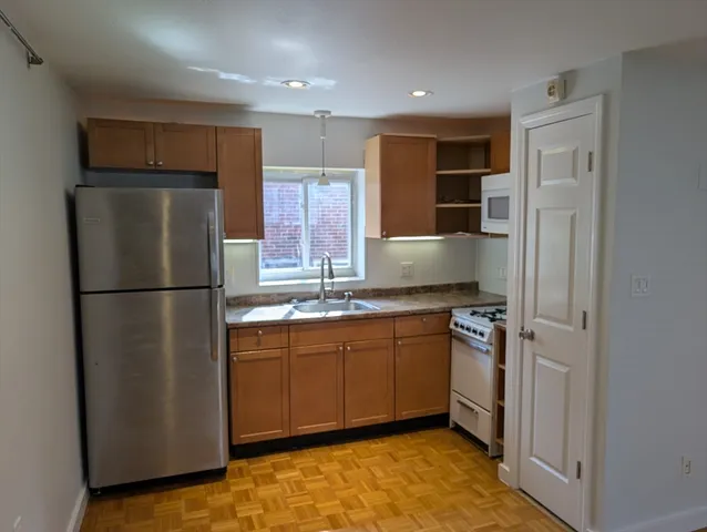 a kitchen with stainless steel appliances granite countertop a refrigerator a sink and a stove