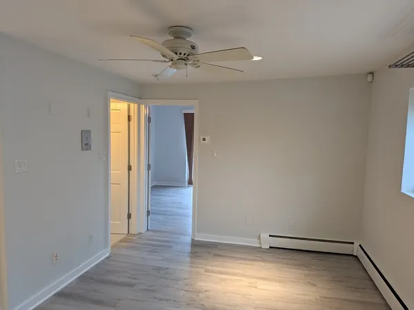 a view of a room with wooden floor and fan
