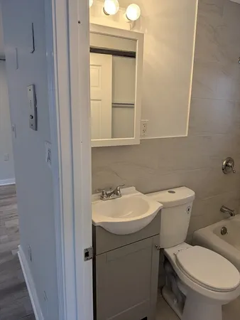 a bathroom with a toilet sink and mirror