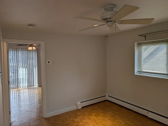 an empty room with a window and a ceiling fan