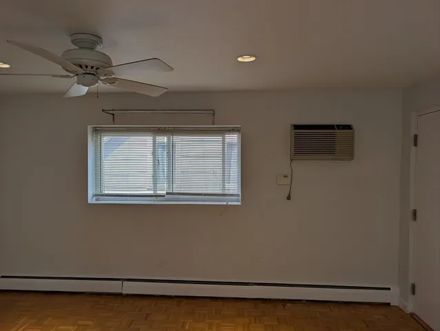 a view of a room with wooden floor and fan