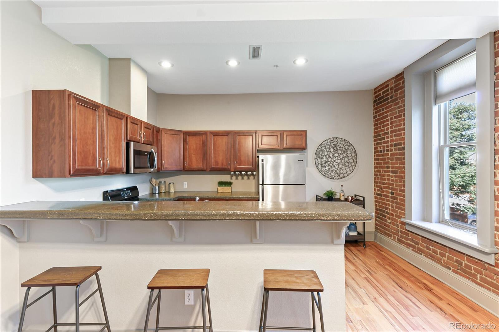 3211 Zuni Street, Unit 4 Denver, CO 80211 - Photo 13 of 35 a kitchen with stainless steel appliances granite countertop a sink a stove a refrigerator cabinets and chairs