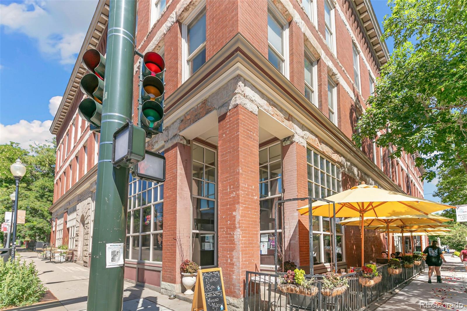 3211 Zuni Street, Unit 4 Denver, CO 80211 - Photo 32 of 35 a city street lined with tall buildings and a umbrellas