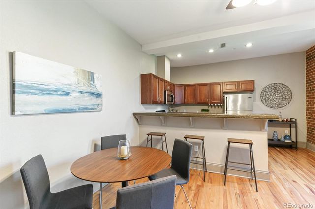 a living room with kitchen island furniture a chandelier and kitchen view