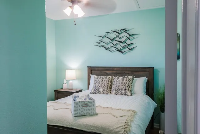 a bed sitting in a bedroom next to a bathroom with a chandelier