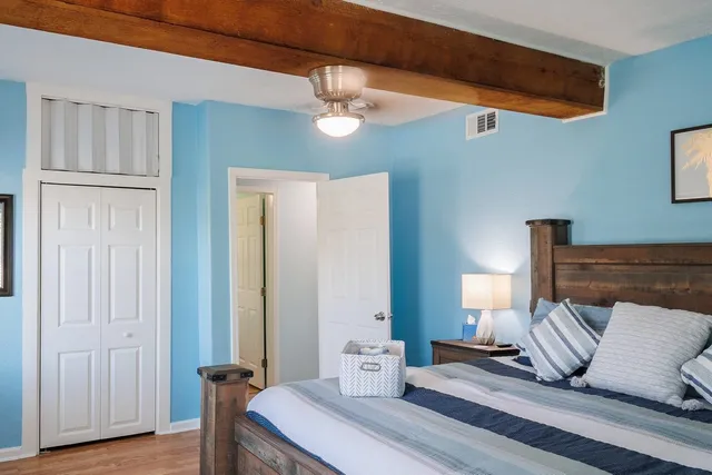 a bedroom with a bed and wooden floor