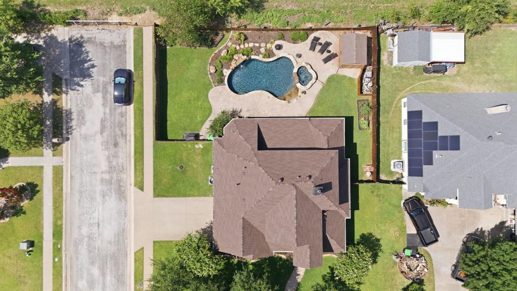 600 Aspen Street Pilot Point, TX 76258 - Photo 36 of 39 Rear yard featuring a freeform swimming pool with integrated spa, stone coping, and surrounding concrete patio
