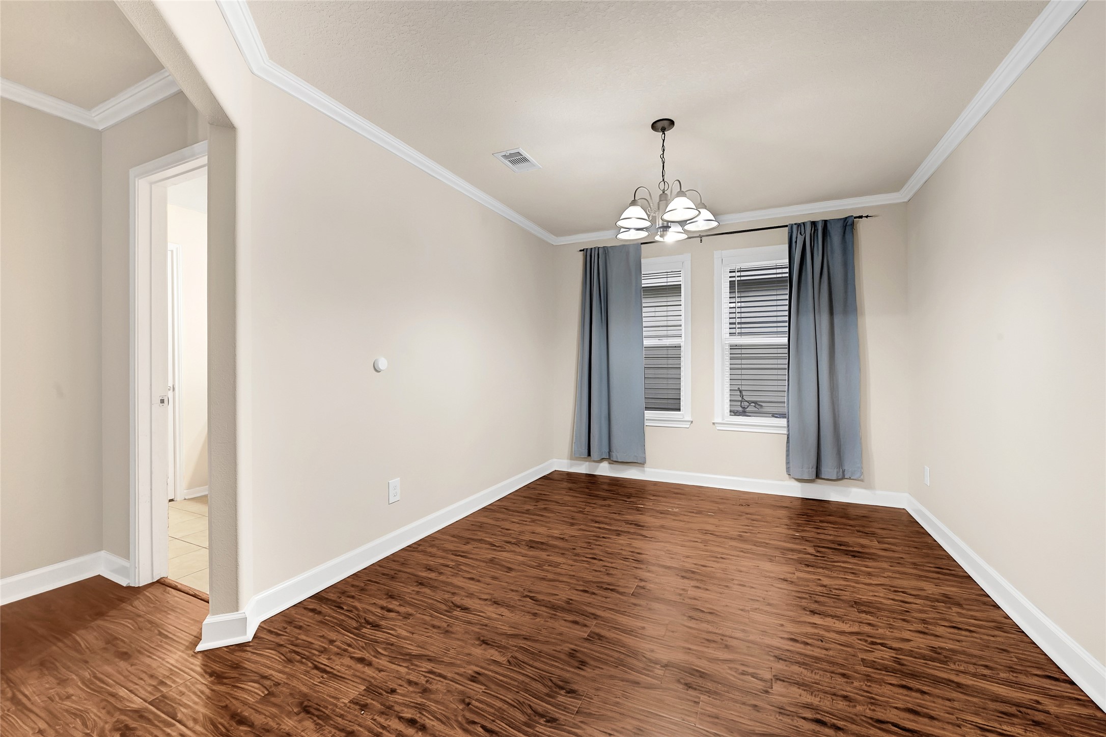 3603 Barkers Crossing Avenue Houston, TX 77084 - Photo 12 of 34 an empty room with wooden floor chandelier and windows