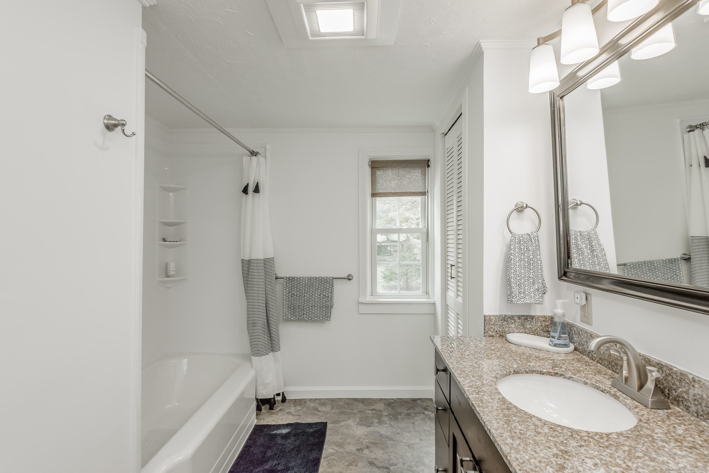 21 Elsmere Road Hebron, CT 06231 - Photo 12 of 31 a bathroom with a granite countertop sink a mirror and a bathtub