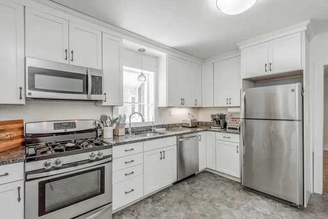 a kitchen with cabinets stainless steel appliances and wooden cabinets