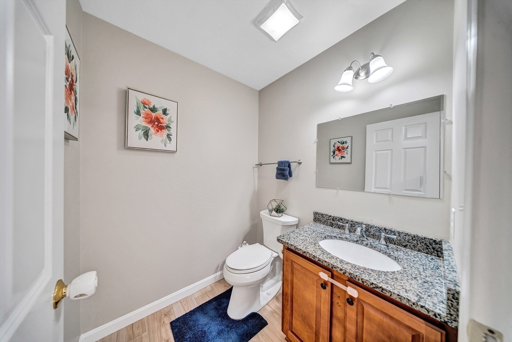 41 Boston Road, Unit 121 Billerica, MA 01862 - Photo 5 of 13 a bathroom with a granite countertop toilet a sink and a mirror
