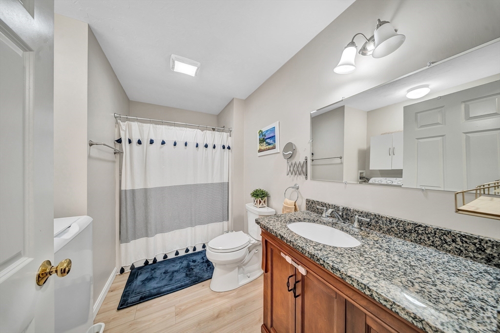 41 Boston Road, Unit 121 Billerica, MA 01862 - Photo 9 of 13 a bathroom with a granite countertop sink a toilet and shower