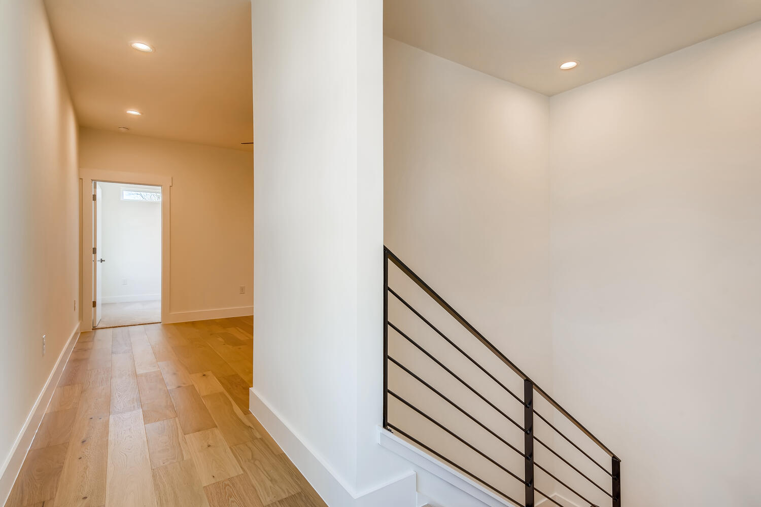 505 Kemp Street Austin, TX 78741 - Photo 18 of 34 Upstairs hallway with a sleek modern stair rail and a bright, open feel.