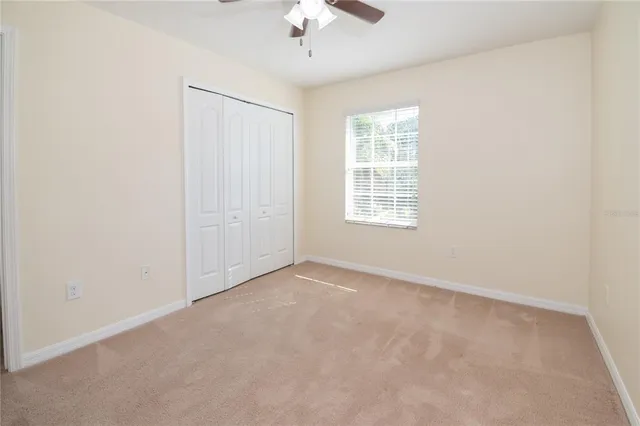 an empty room with a window and a fan