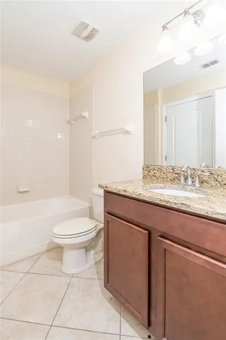 a bathroom with a granite countertop sink toilet and mirror