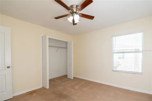 an empty room with a window and a fan