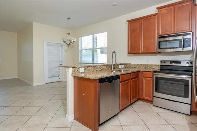 a kitchen with granite countertop a sink stove and microwave
