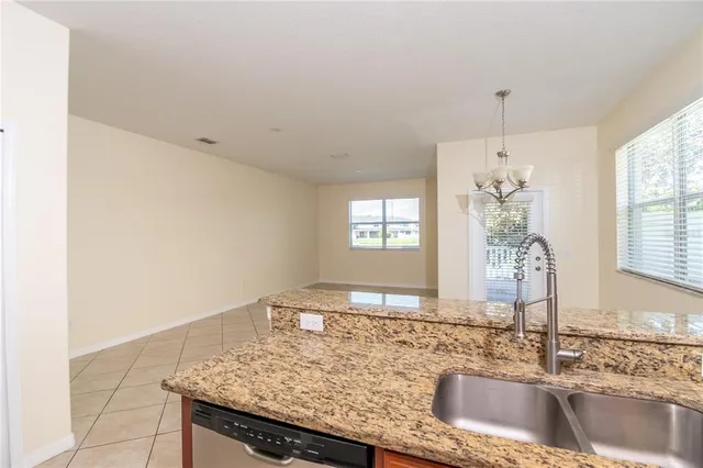 a kitchen with granite countertop a sink a stove and a window