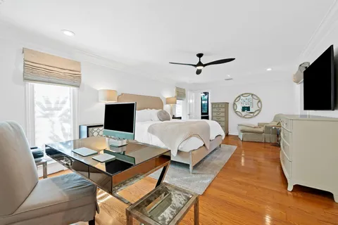 a living room with furniture a clock and a flat screen tv