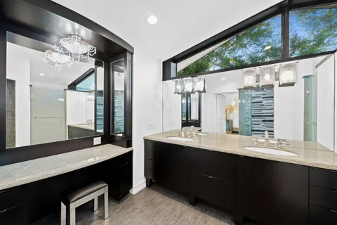 a bathroom with a double vanity sink a mirror and a bathtub