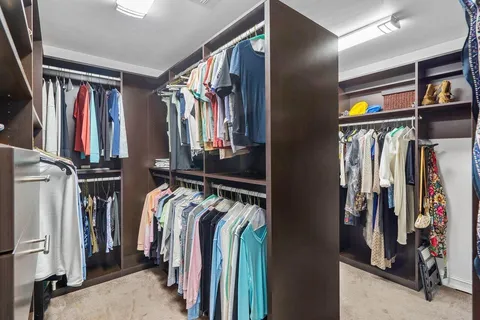 a view of walk in closet with clothes and shoes