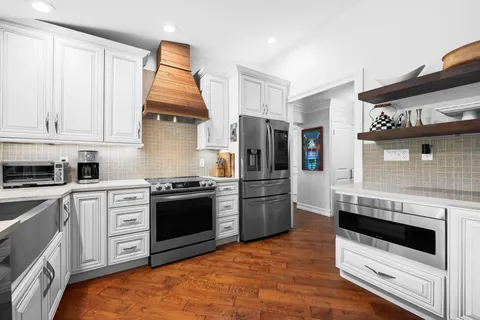 a kitchen with stainless steel appliances granite countertop a stove a refrigerator and a microwave