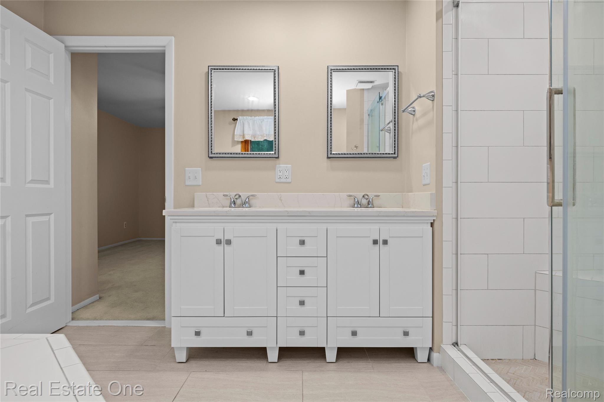 39750 Cheviot Road Canton, MI 48188 - Photo 40 of 71 Dual vanity with white cabinetry, integrated sinks, chrome fixtures, and stone countertop