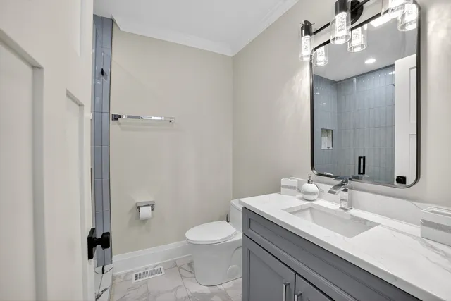 a bathroom with a sink a toilet and shower