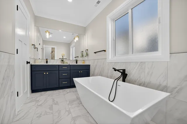 a bathroom with a tub sink and mirror