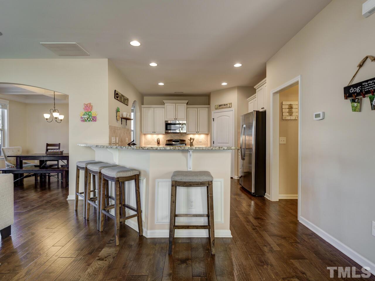 207 Maple Walk Street Durham, NC 27703 - Photo 20 of 50 a open kitchen with stainless steel appliances granite countertop a refrigerator a stove a sink a dining table and chairs with wooden floor