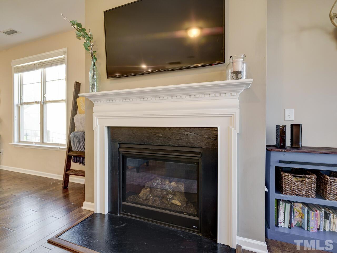 207 Maple Walk Street Durham, NC 27703 - Photo 22 of 50 a living room with a fireplace and a flat screen tv