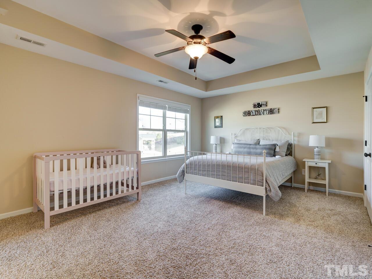207 Maple Walk Street Durham, NC 27703 - Photo 32 of 50 a bedroom with a bed and a chandelier
