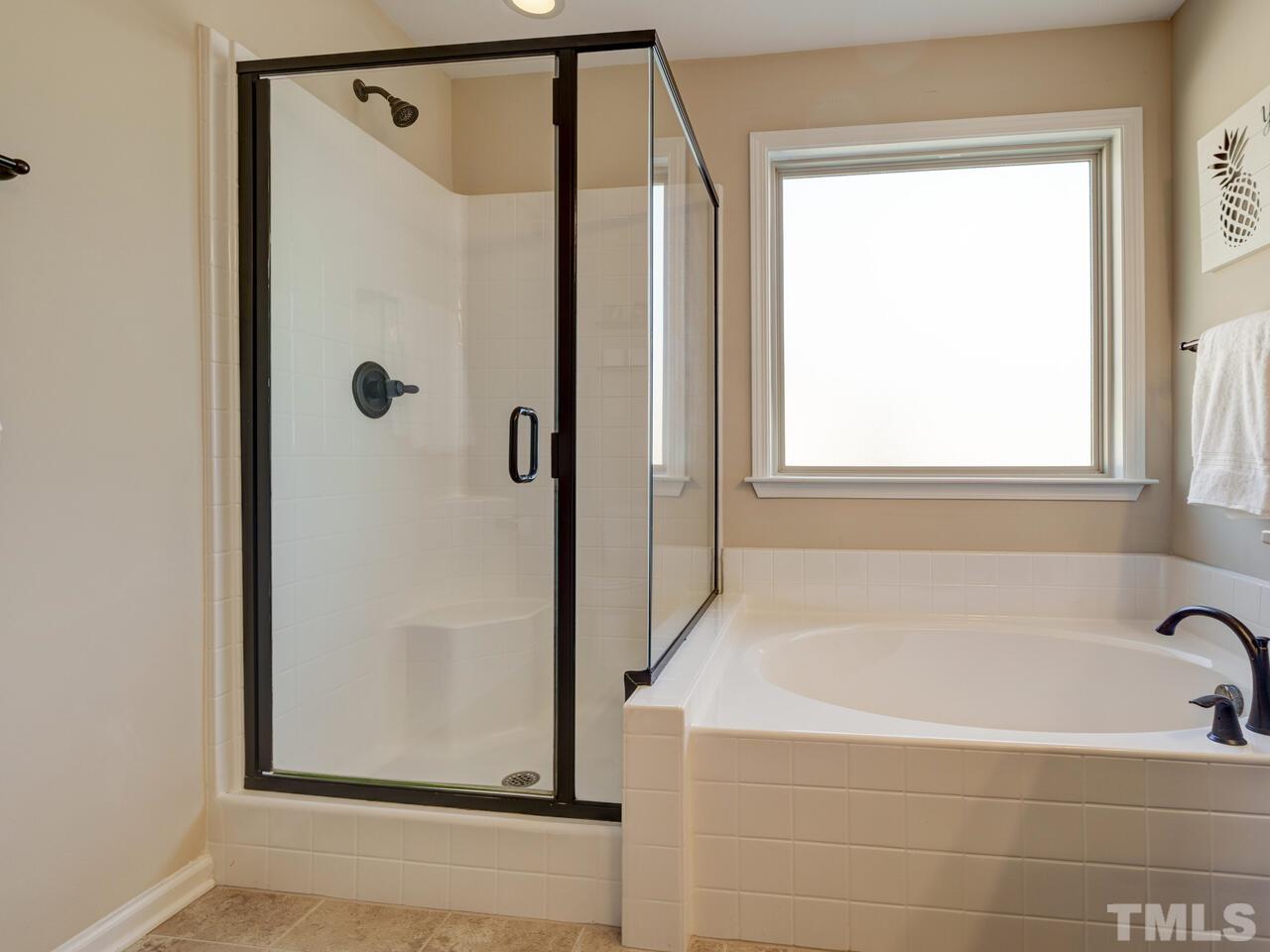 207 Maple Walk Street Durham, NC 27703 - Photo 34 of 50 a bathroom with a bathtub and a shower