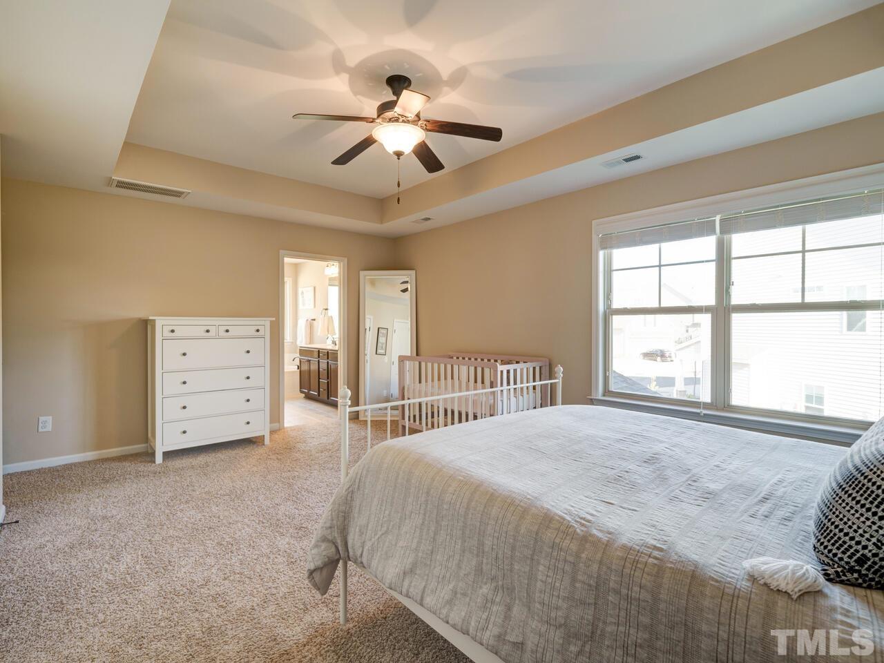 207 Maple Walk Street Durham, NC 27703 - Photo 36 of 50 a spacious bedroom with a bed and a chandelier