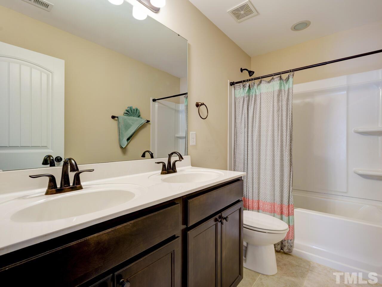 207 Maple Walk Street Durham, NC 27703 - Photo 40 of 50 a bathroom with a sink a toilet a mirror and shower
