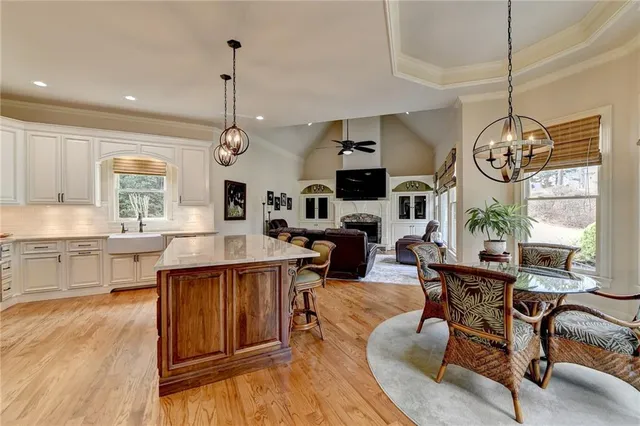 a kitchen with stainless steel appliances kitchen island a large white table and chairs