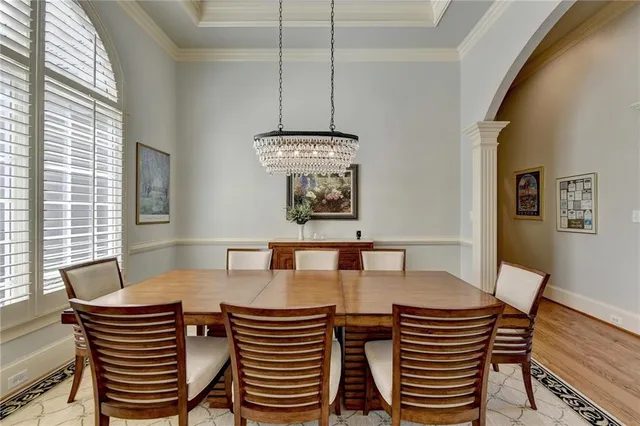a dining room with furniture a chandelier and wooden floor