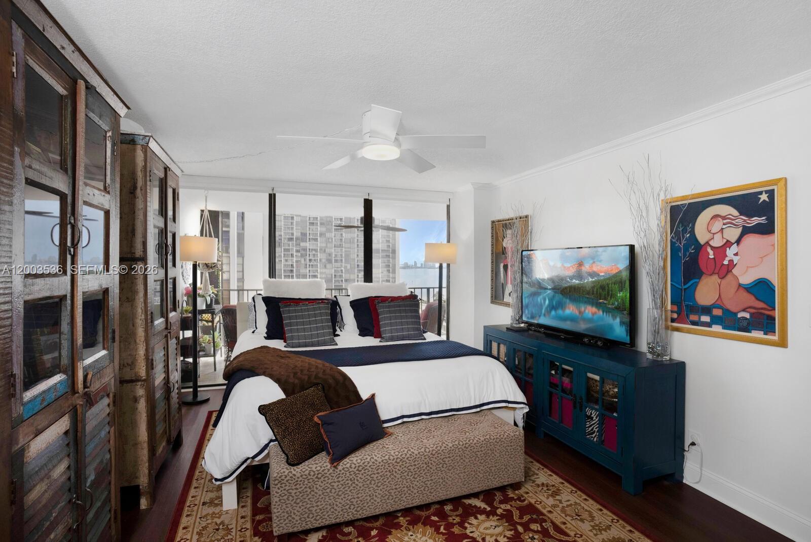 1925 Brickell Avenue, Unit 1003 Miami, FL 33129 - Photo 11 of 16 a living room with furniture a flat screen tv and a wall painting
