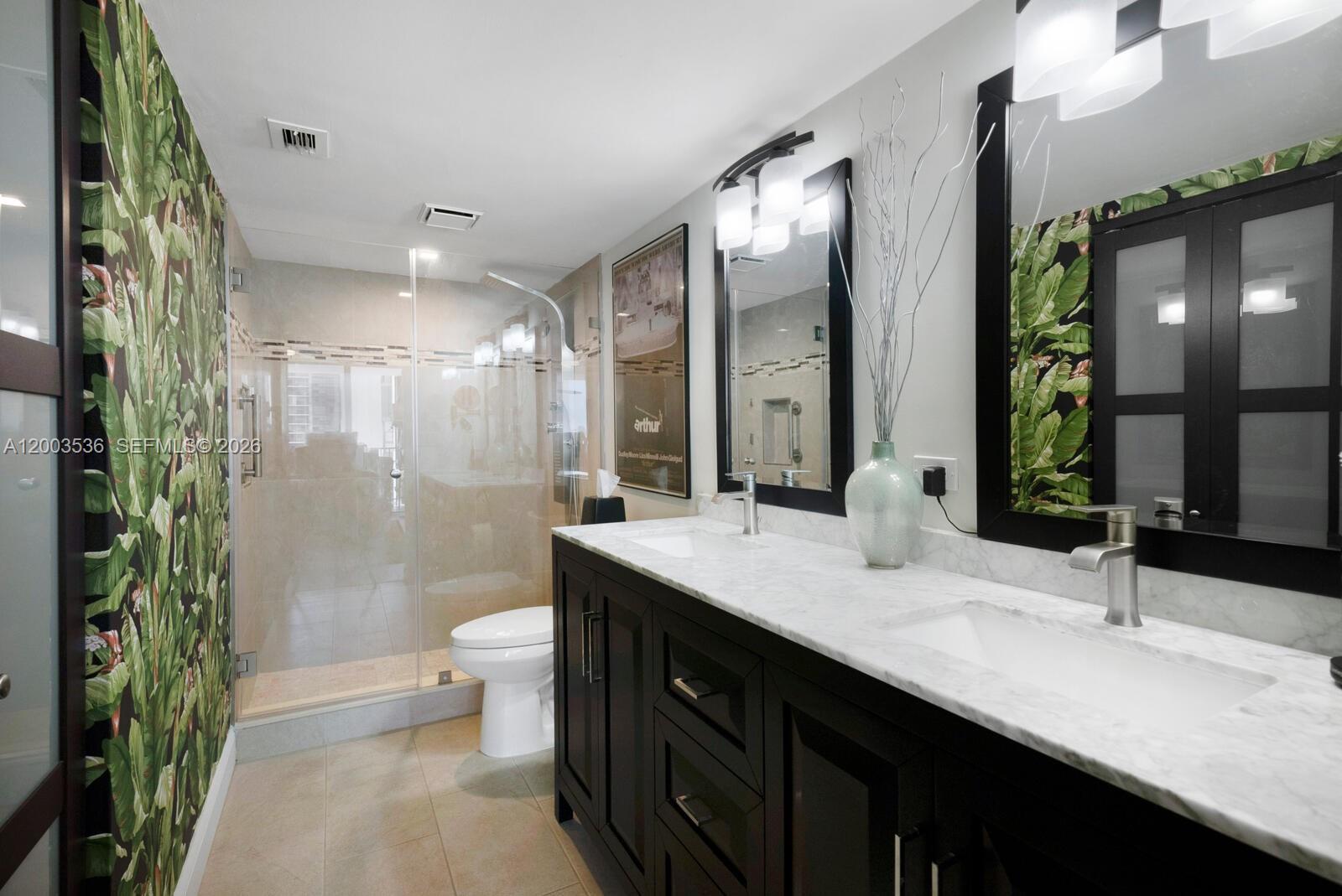 1925 Brickell Avenue, Unit 1003 Miami, FL 33129 - Photo 13 of 16 a bathroom with a double vanity sink toilet and shower
