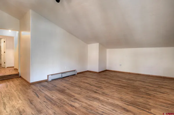 a view of an empty room and wooden floor