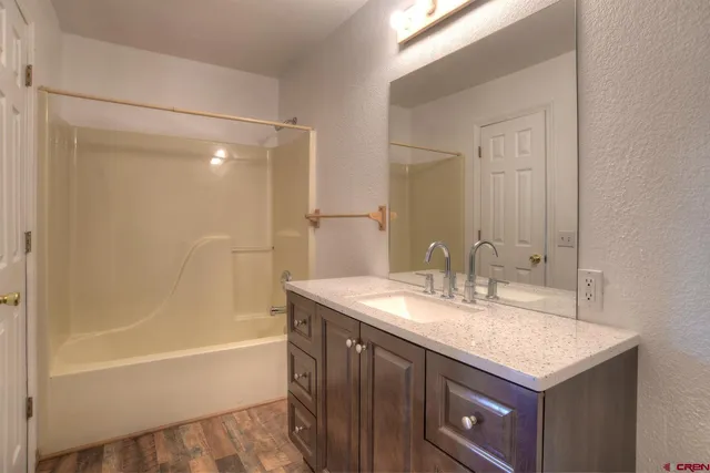 a bathroom with a granite countertop sink toilet a large mirror a vanity and shower