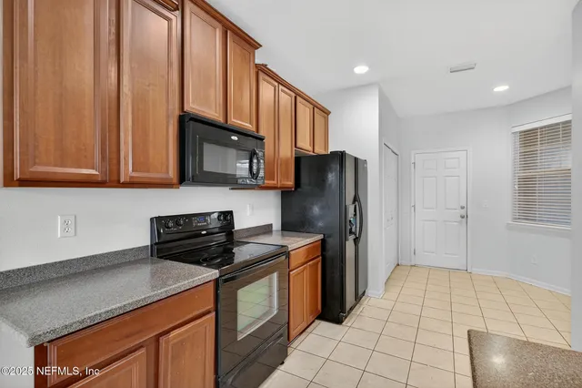 a kitchen with stainless steel appliances granite countertop a refrigerator a stove and a sink