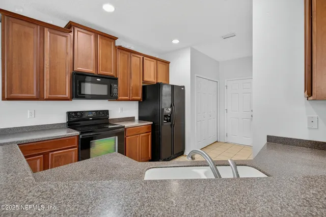a kitchen with stainless steel appliances granite countertop a stove a sink dishwasher a refrigerator and a microwave